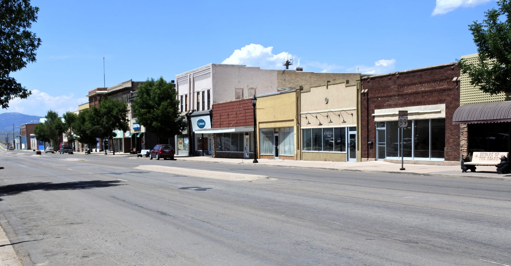 Washington Street in downtown Montpelier, Idaho, lined with brick storefronts under a blue sky