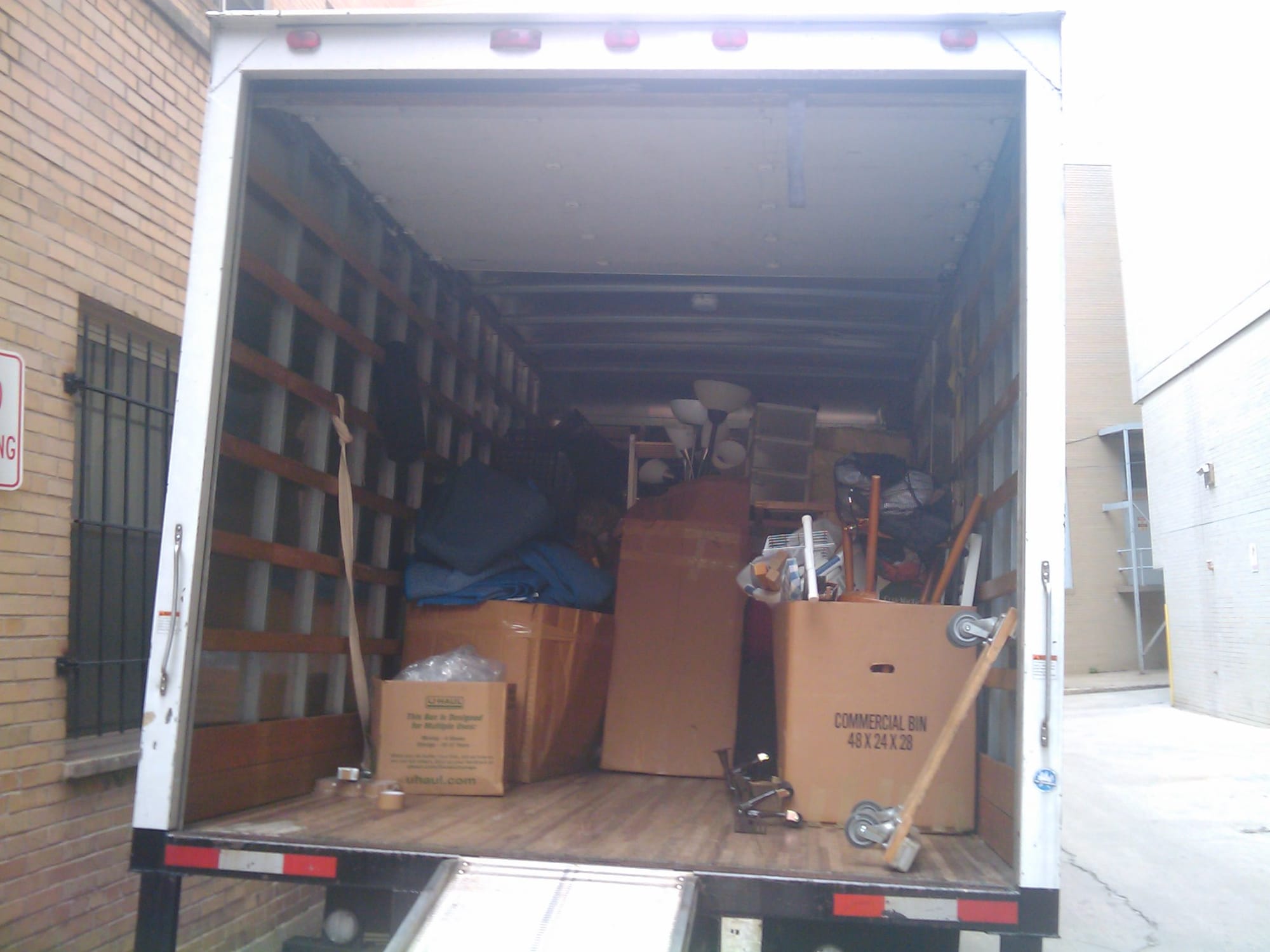 The open back of a moving truck packed with boxes and furniture
